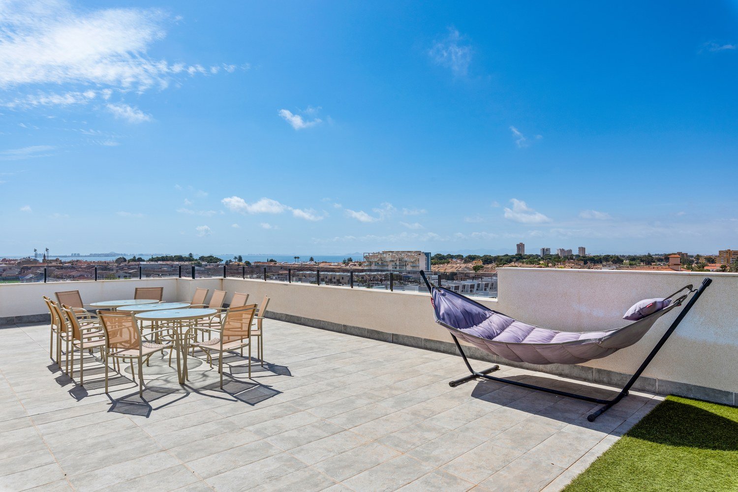 Dachterrasse mit Esstischen und H&auml;ngematte