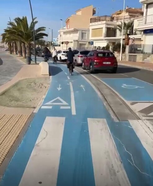 Fietsers fietsen langs rivier met palmen
