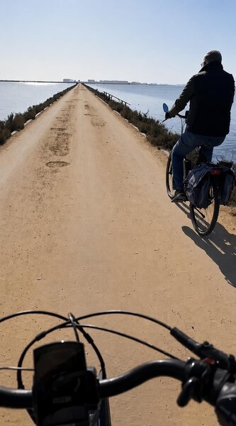 Fietsers genieten van uitzicht op strand en water