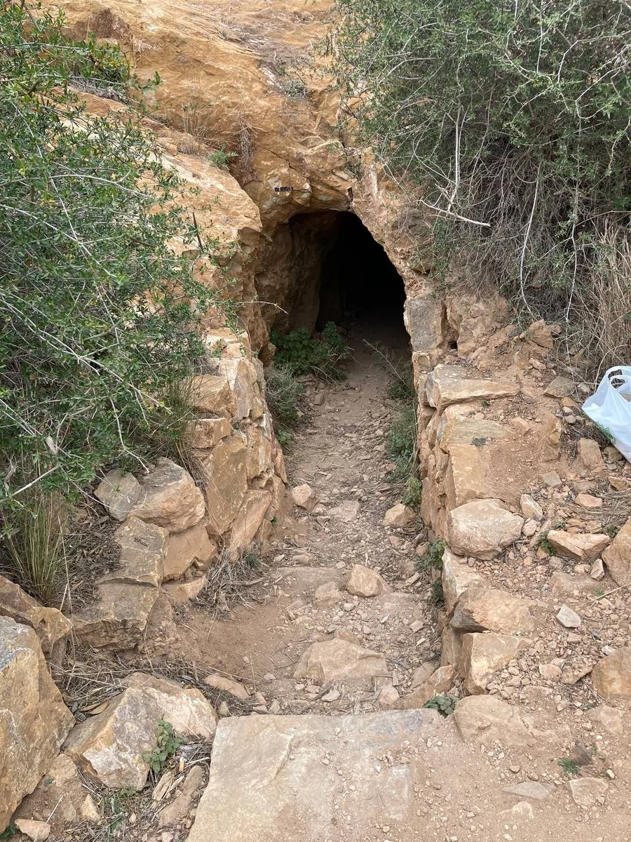 Entrada de un túnel en la ladera rocosa del Cabezo Gordo con un camino de piedra que conduce a ella
