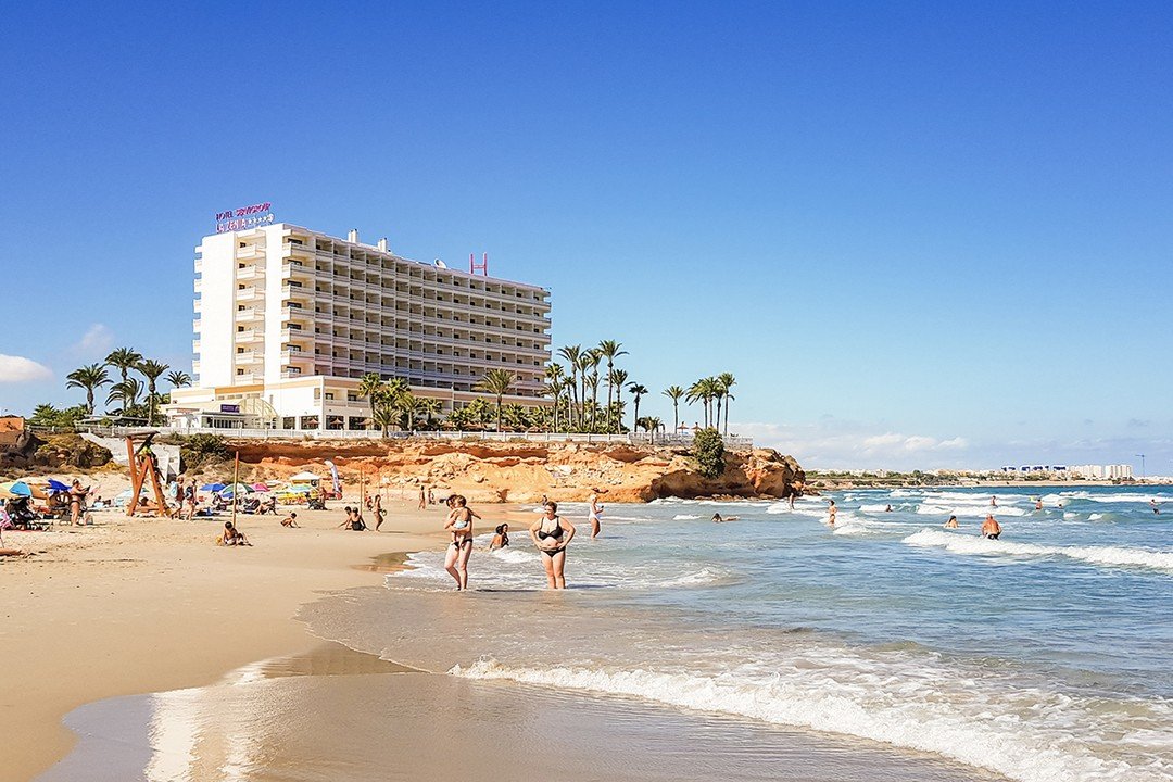 Sandstrand mit Hotel auf den Felsen bei La Zenia, Orihuela Costa