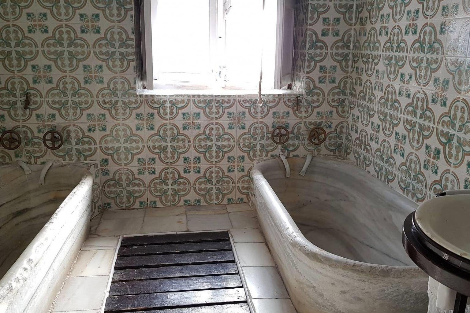 Zwei Badewannen aus einem St&uuml;ck Marmor mit originalen Armaturen an geflie&szlig;ter Wand