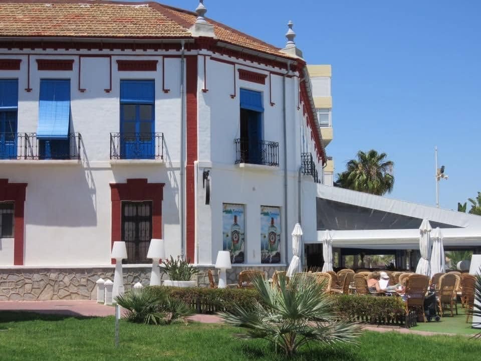 Fassade des Hotel Balneario La Encarnaci&oacute;n mit blauen L&auml;den und rot-wei&szlig;em Putz