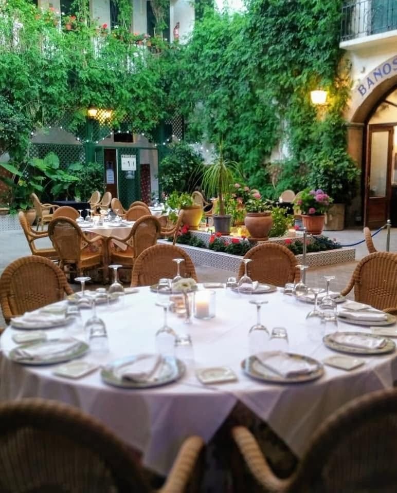 Gedeckter Tisch im begr&uuml;nten Innenhof des Balneario La Encarnaci&oacute;n im Abendlicht