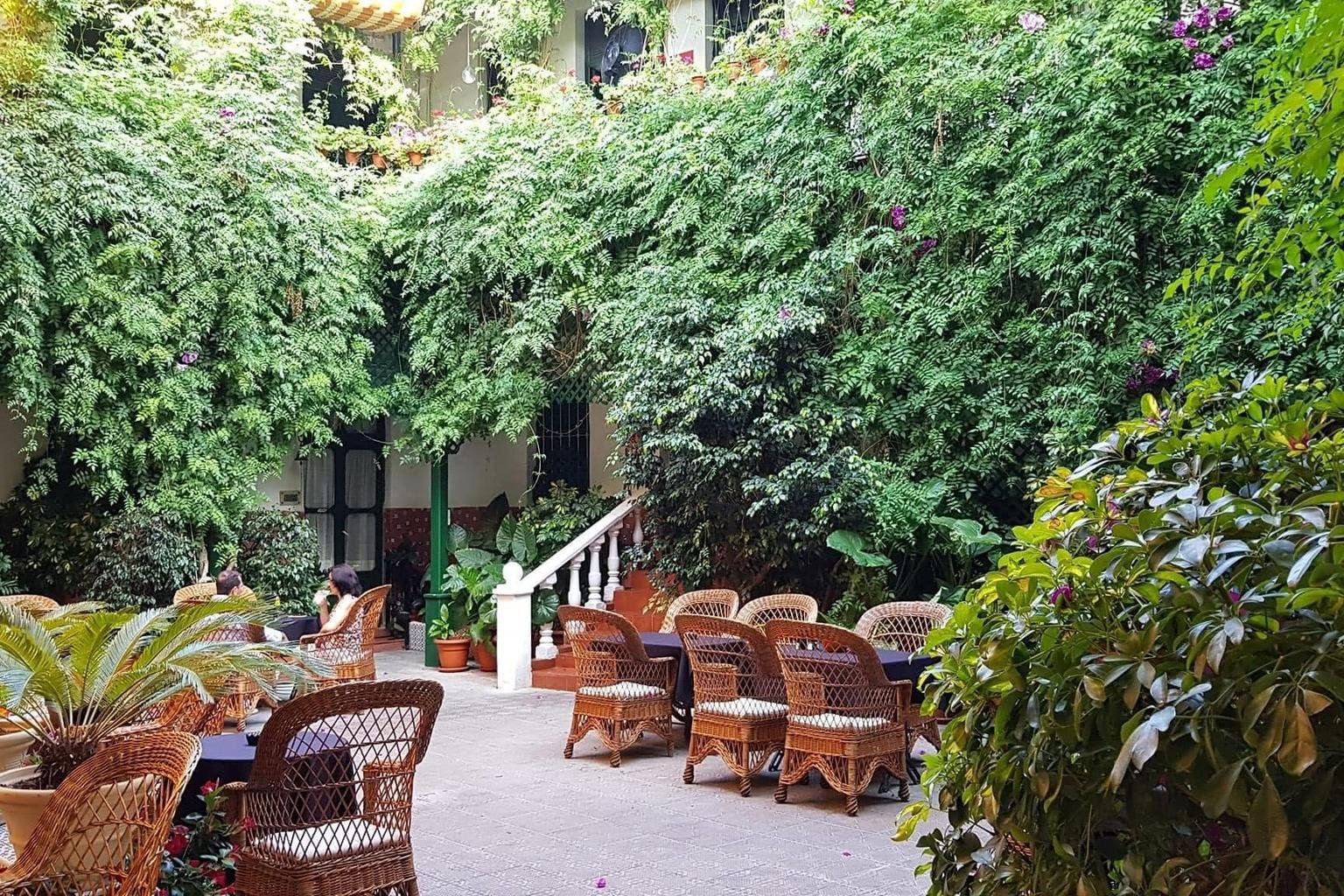 Begr&uuml;nter Innenhof des Balneario La Encarnaci&oacute;n in Los Alc&aacute;zares mit Korbsesseln