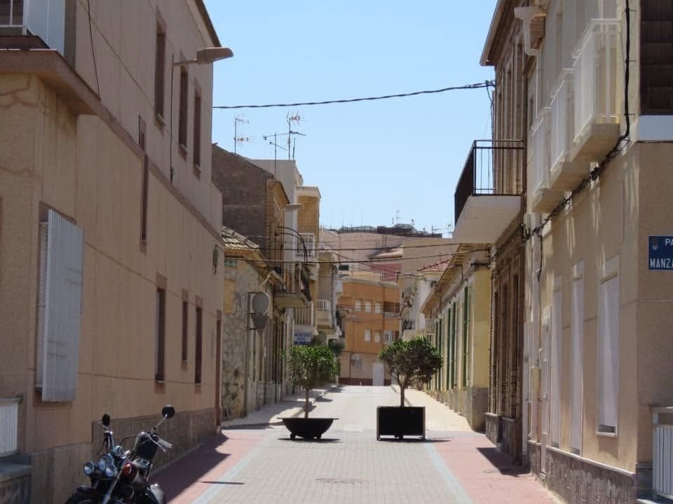 Leere Stra&szlig;e in Los Alc&aacute;zares w&auml;hrend der Siesta mit Pflanzk&uuml;beln und geparktem Roller