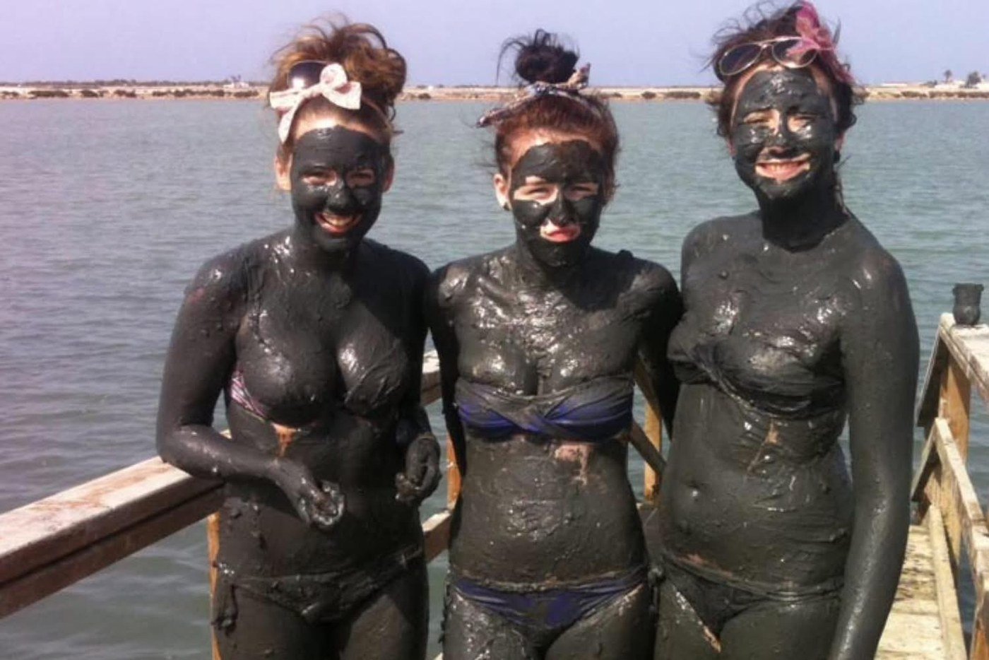 Visitantes completamente cubiertos por el lodo oscuro y mineral del Mar Menor en Lo Pag&aacute;n