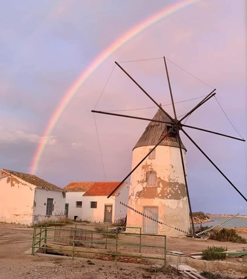 Molino salinero hist&oacute;rico cerca de Lo Pag&aacute;n bajo un arco&iacute;ris al atardecer