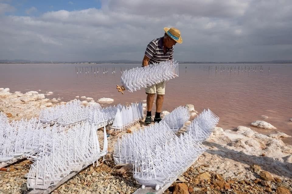 Dozens of salt-covered ship models on the shore of the lagoon of Torrevieja